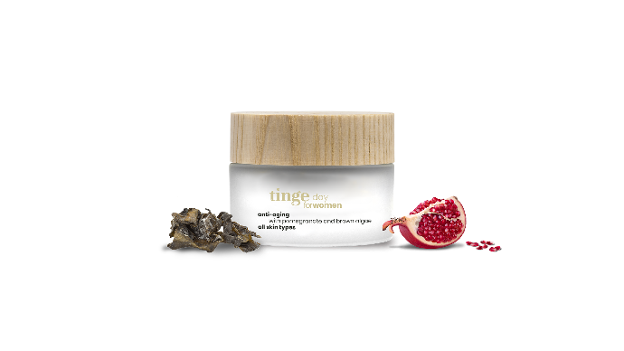 tinge anti aging daycream for women with pomegranate and brown algae on a white background