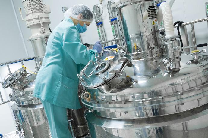 production in mixers person standing next to industrial mixers