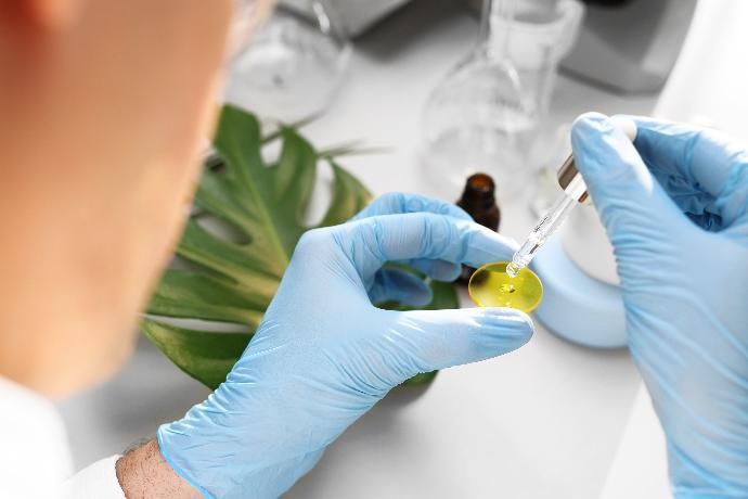 R&D person putting drops of a liquid on a yellow disc