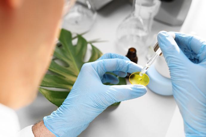 person putting drops of a liquid on a yellow disc